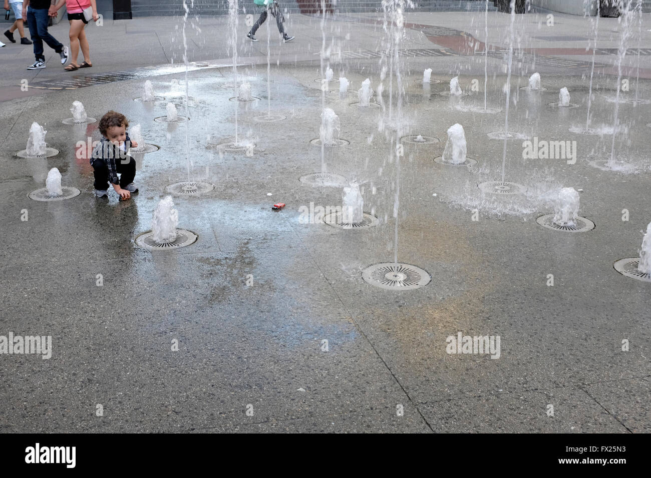 Child playing in fountain in outdoor mall near Hollywood Walk of Fame, Los Angeles, California Stock Photo