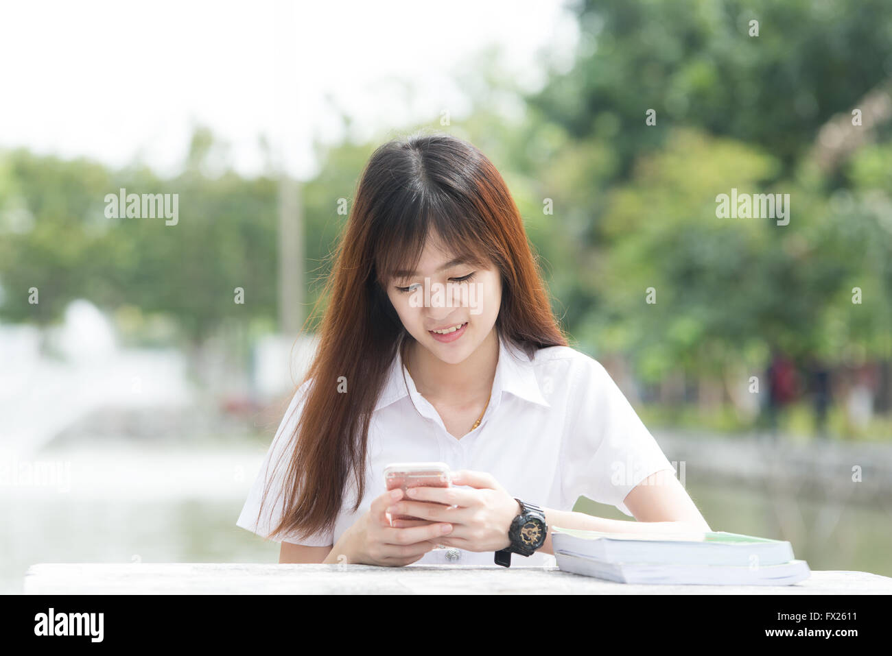 Asian student with uniform using smartphone in university Stock Photo ...