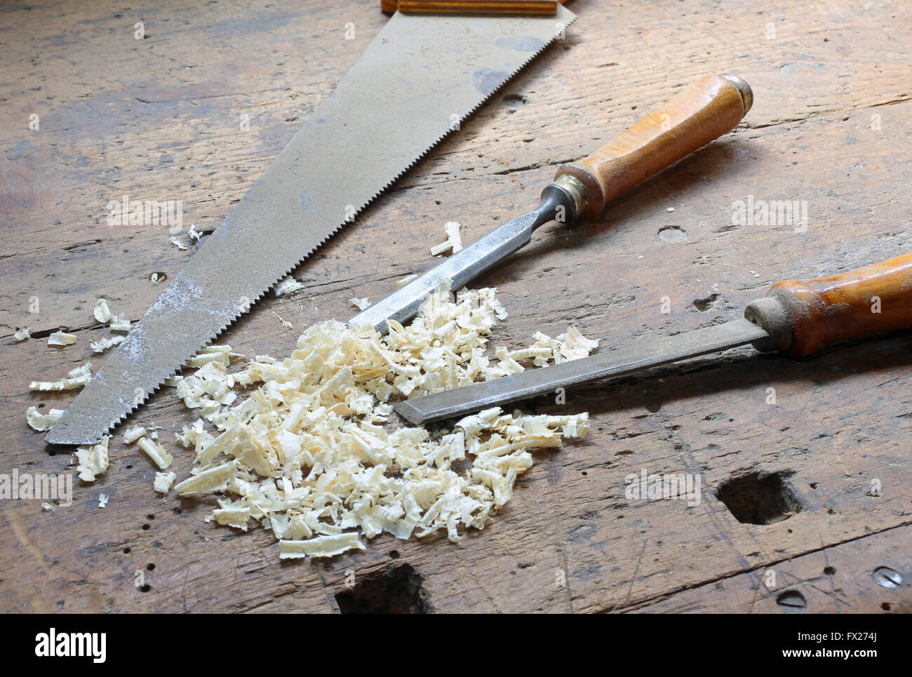 two chisels and a hand saw with wood shavings in the Workbench with a