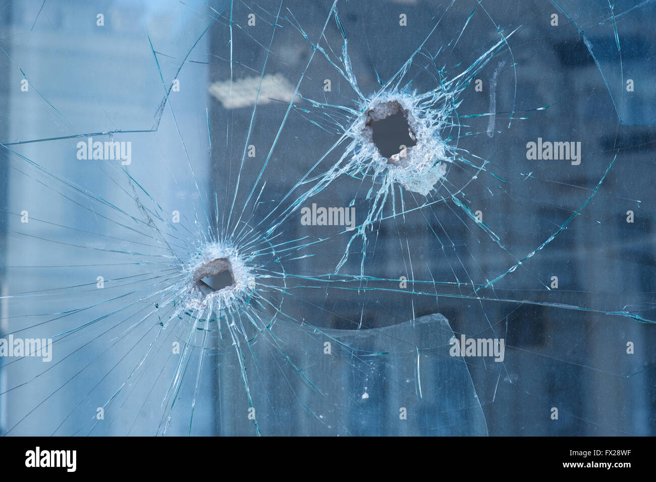 two bullet holes in the glass windows Stock Photo