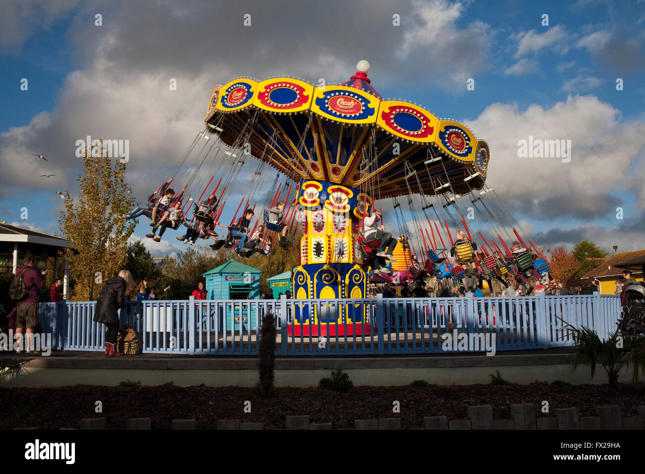 swing chair at a fair enclosed within a fence Stock Photo