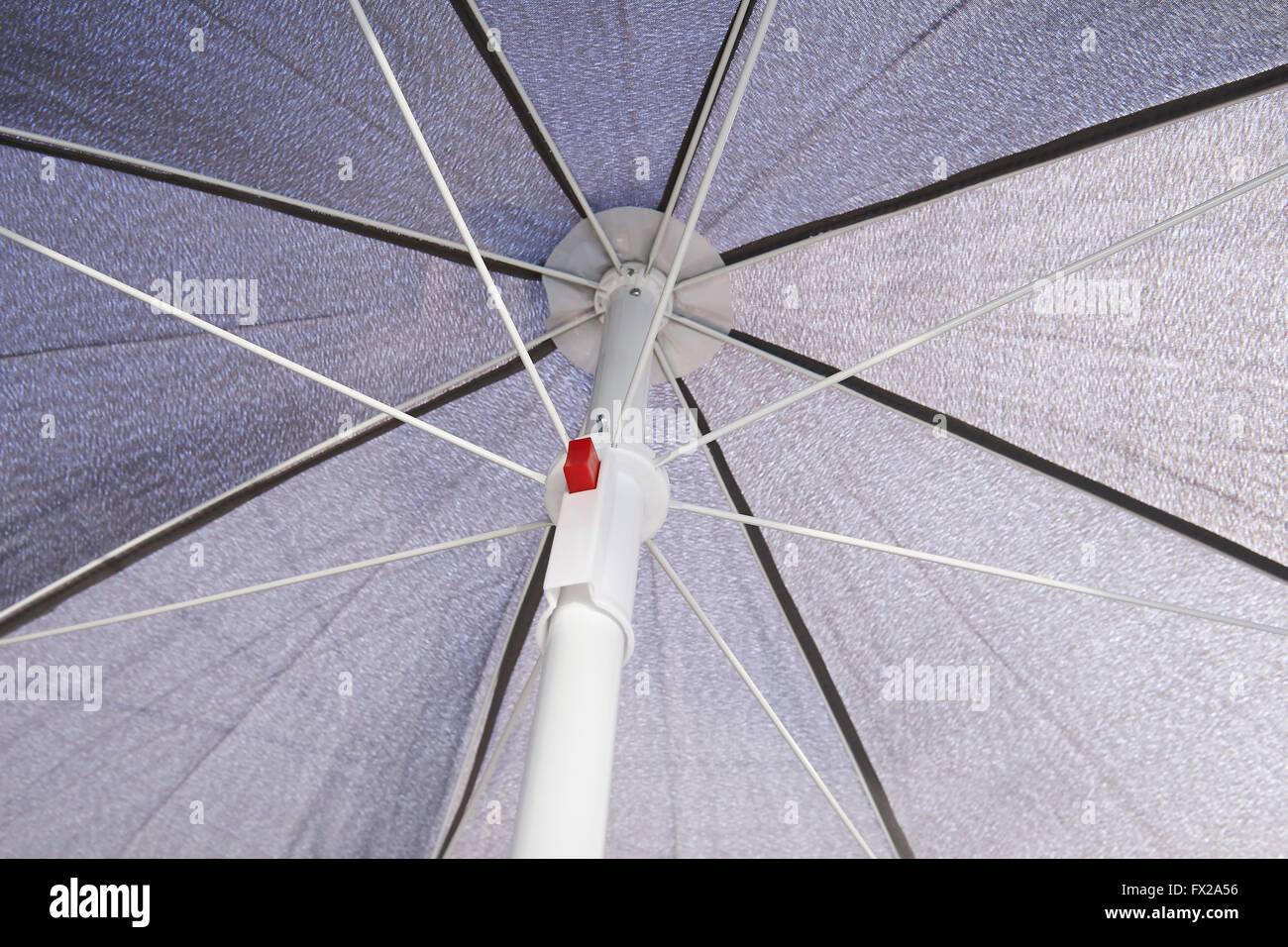 Under a grey sunblock umbrella Stock Photo