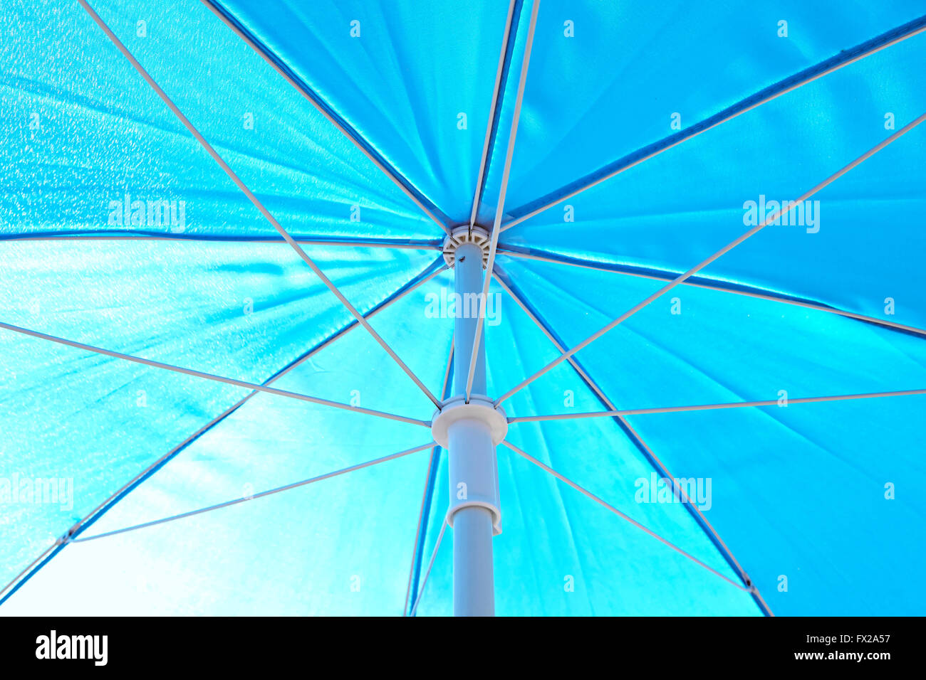 Under a blue sunblock umbrella Stock Photo