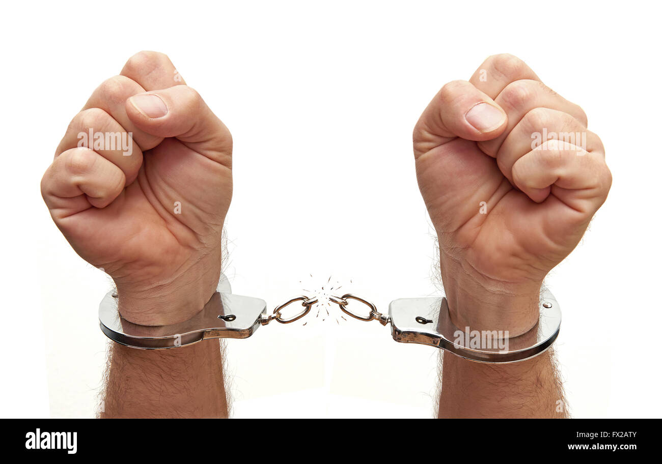 Closeup of a person breaking the chains on metal handcuffs Stock Photo