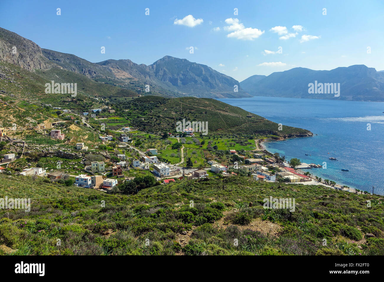 Blue sea, spring greenery and mountains at Emborios Bay Kalymnos, Greece Stock Photo