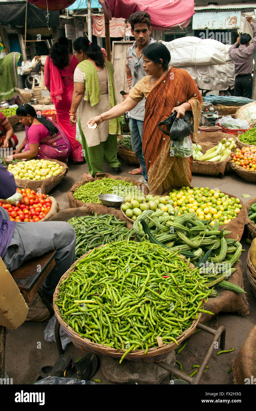 Market in Udaipur selling vegetables with customers in ackground Stock