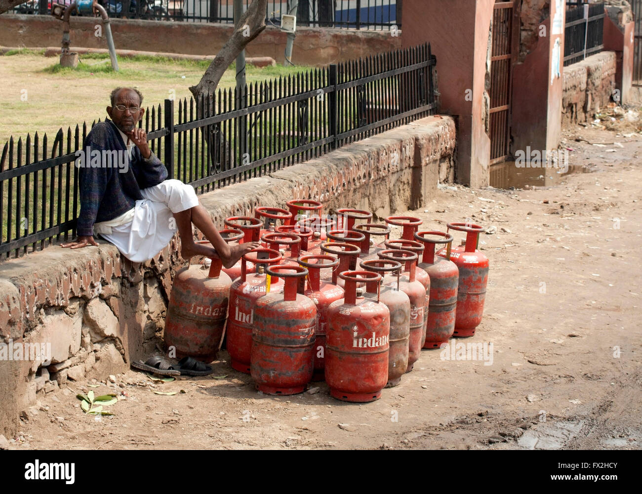 Gas tank vendor Jaipur India sitting on wall with calor gas  tanks Stock Photo