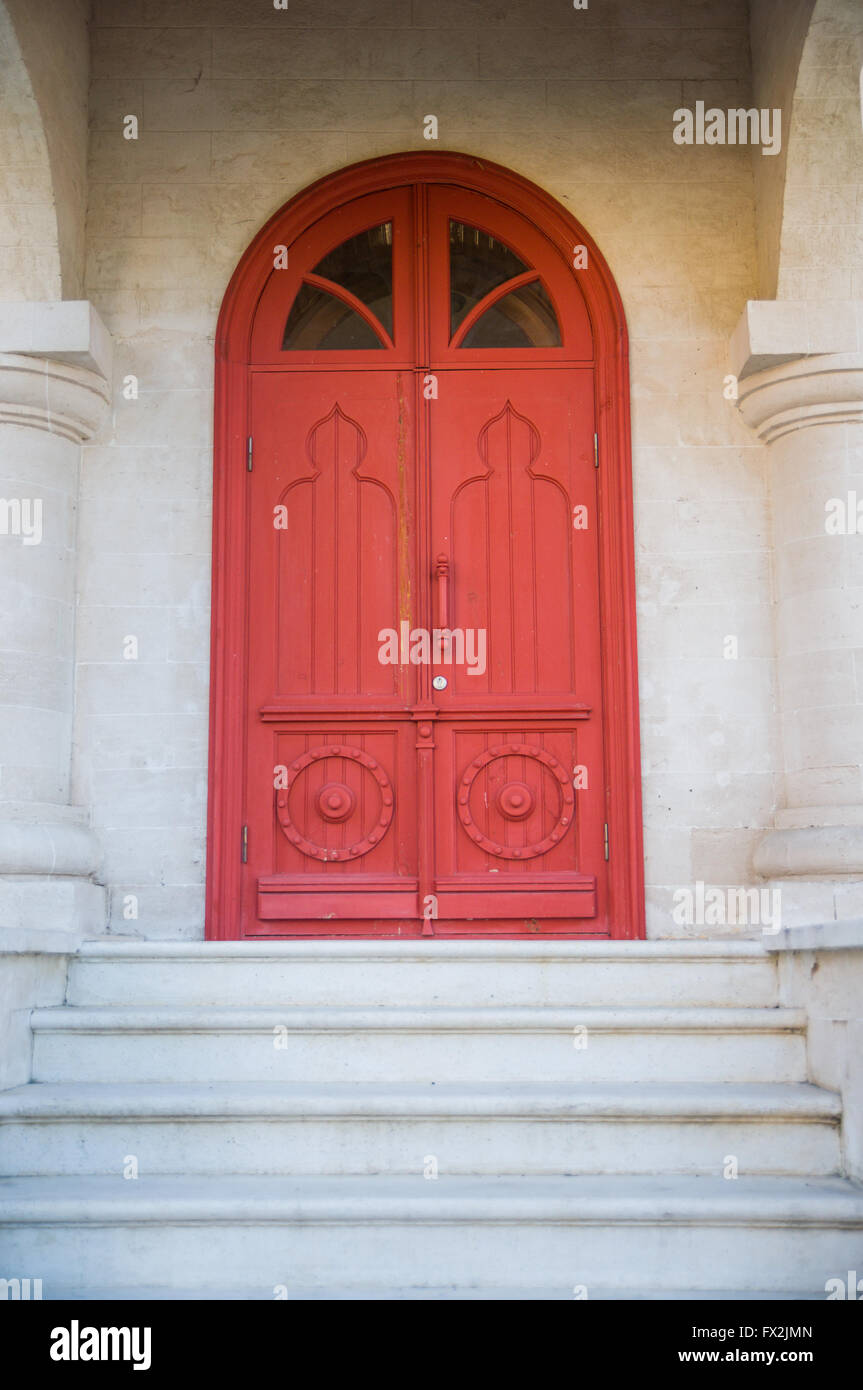 Old red door on a stone building Stock Photo