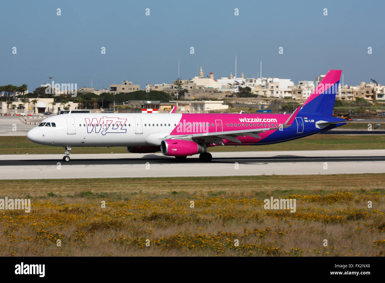 Low cost air travel. Airbus A321 belonging to budget airline Wizz Air departing from Malta International Airport Stock Photo