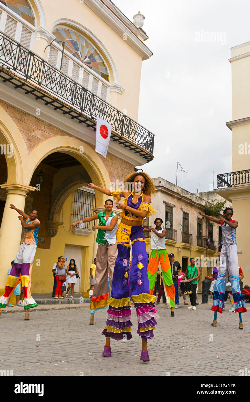 Vertical portrait of stilt walkers performing a dance routine in Havana