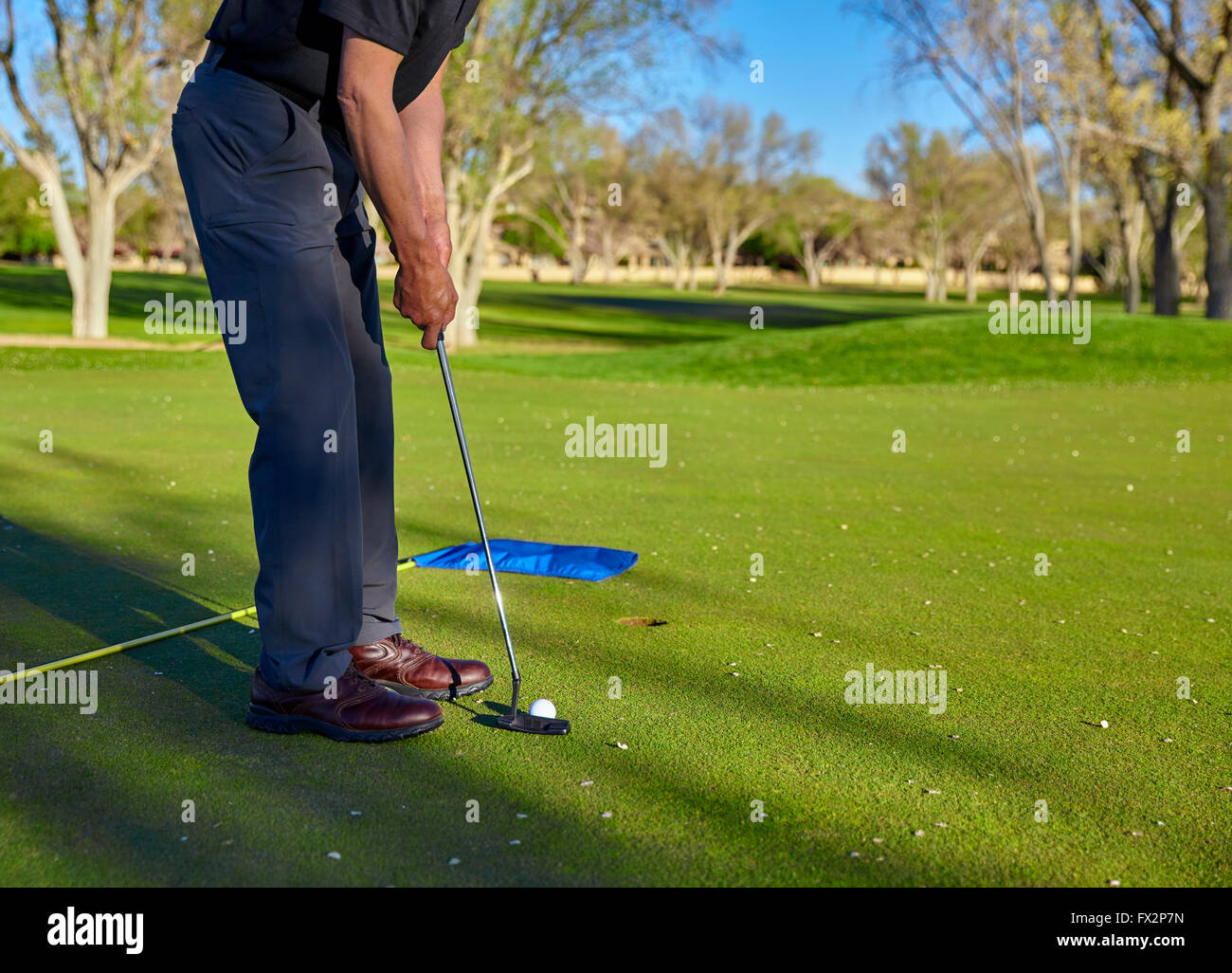 senior retired man with irons and putter on golf course Stock Photo