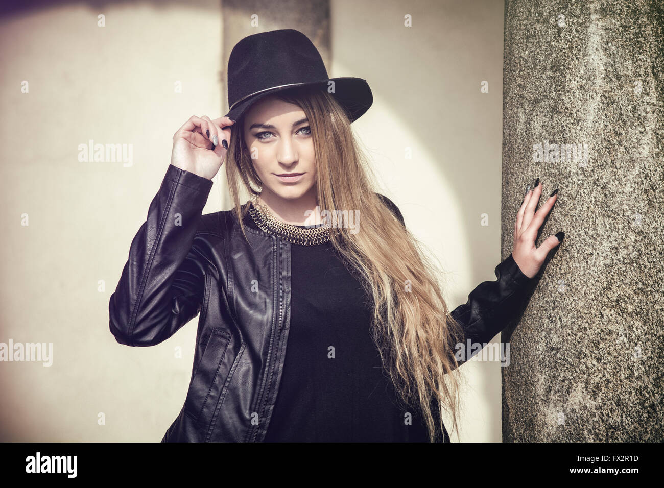 Portrait of attractive blonde young woman in black fedora hat and ...