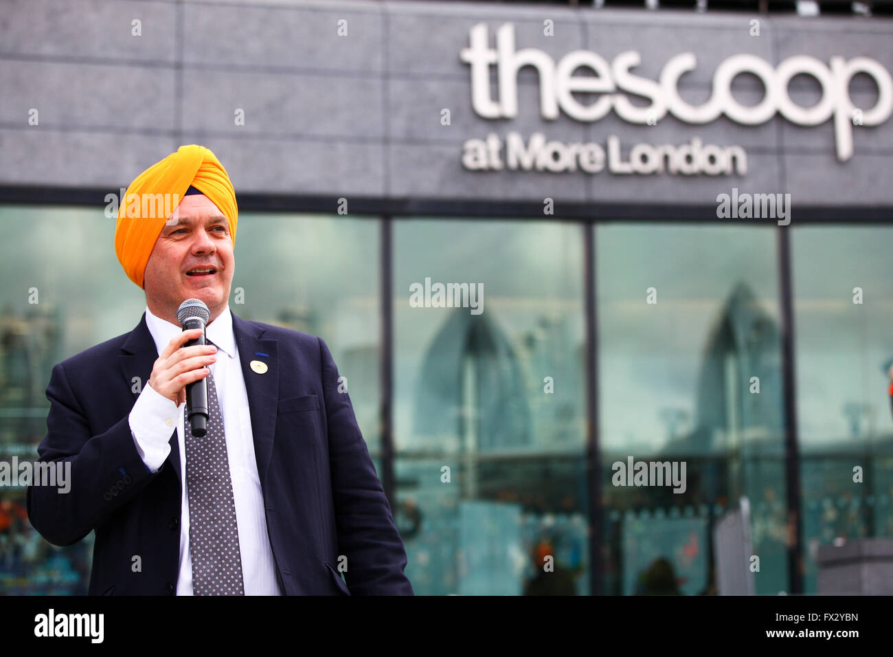 City Hall, London, UK. 9 April 2016. Roger Evans Deputy Mayor of London wearing turban addresses the crowd. Sikhs  from all over the UK celebrates festival of Vaisakhi, (Sikhs’ New Year) inside and outside the City Hall and The Scoop in central London, celebrating the Sikh tradition, heritage, culture, shabad kirtan (spiritual music), langar (food), turban tying, folk music, martial arts, dancing and children’s activities.The festival  is organised by the Mayor of London, with support from Singh Sabha London East and Ernst & Young Sikh Network. Credit:  Dinendra Haria/Alamy Live News Stock Photo