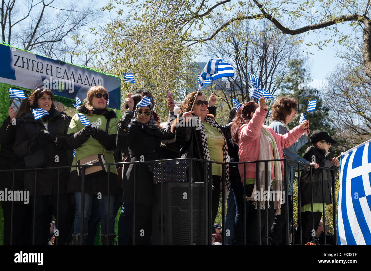 People waving Greek flags on a float in the 2016 New York Greek Parade