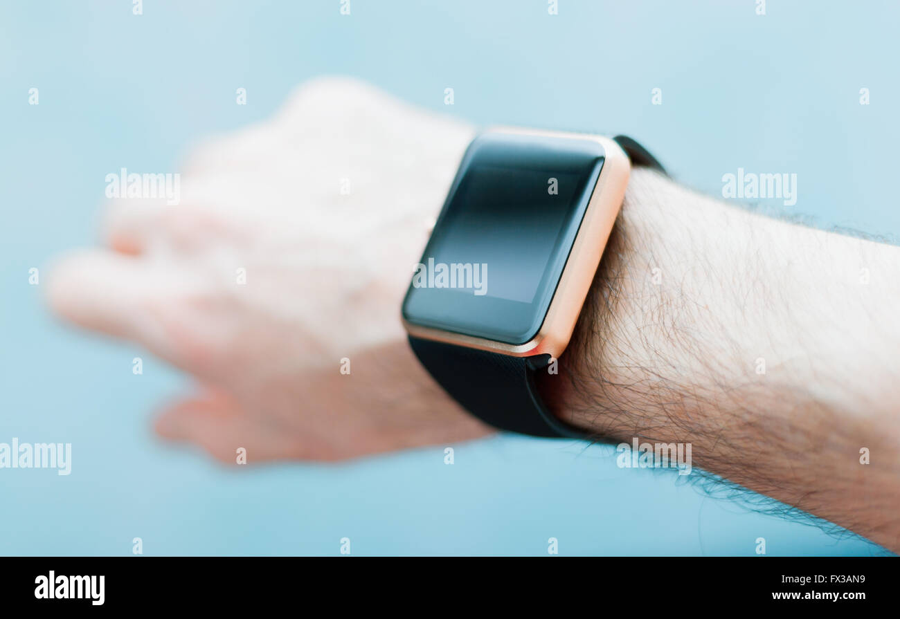Male hand with stylish smart watch. Fashionable technology in real life usage. Focus on wrist watch. Stock Photo