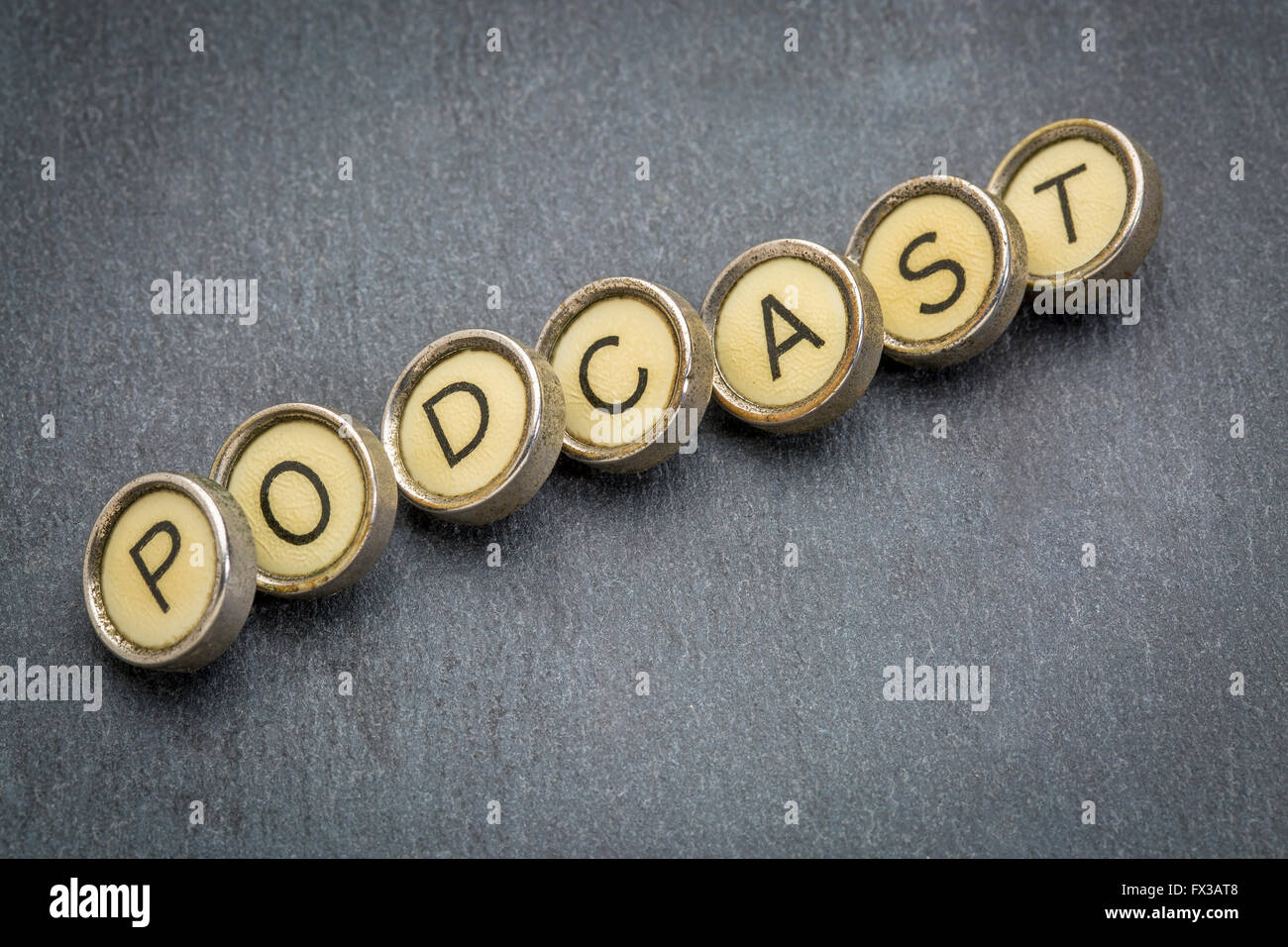 podcast word in old round typewriter keys against gray slate stone Stock Photo