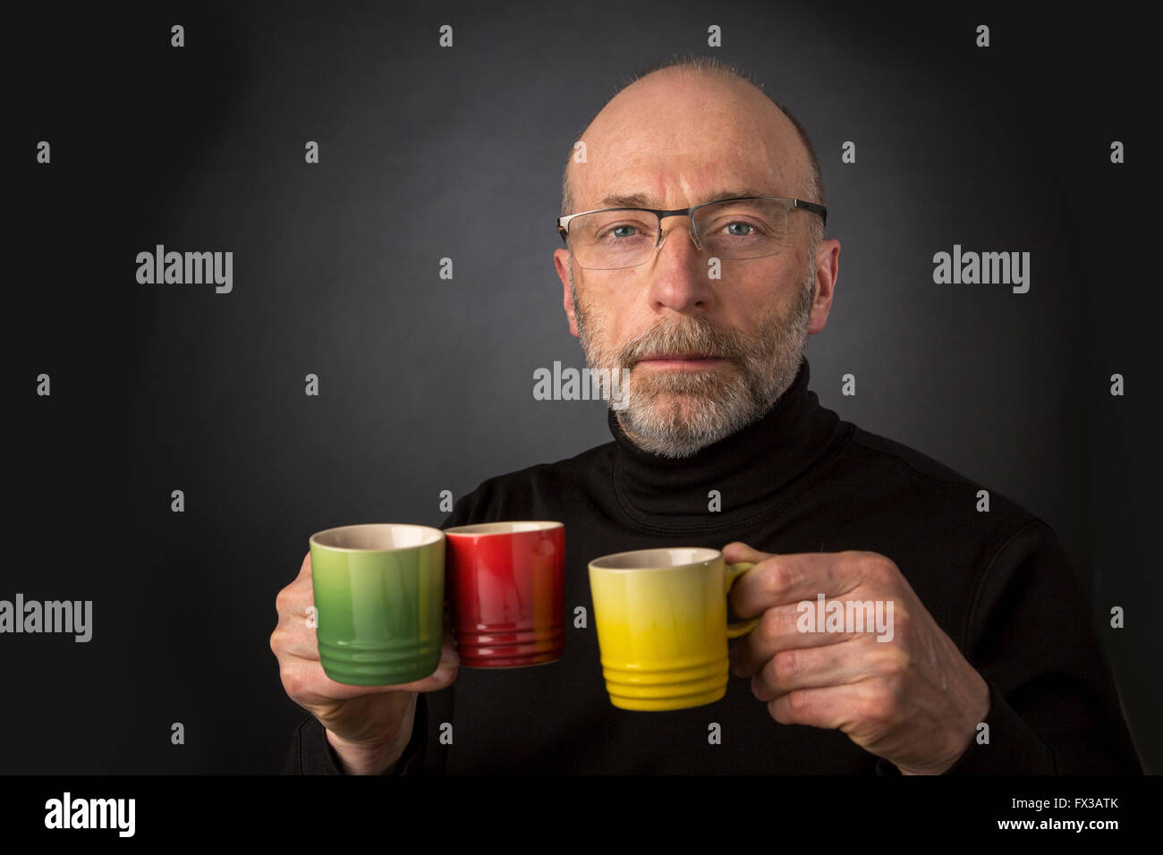 Morning coffee anybody? 60 years old  bald man with a beard and glasses carrying three espresso coffee cups Stock Photo