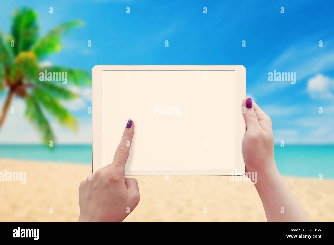 Woman work on tablet with blank screen. Summer time, beach in background. Stock Photo