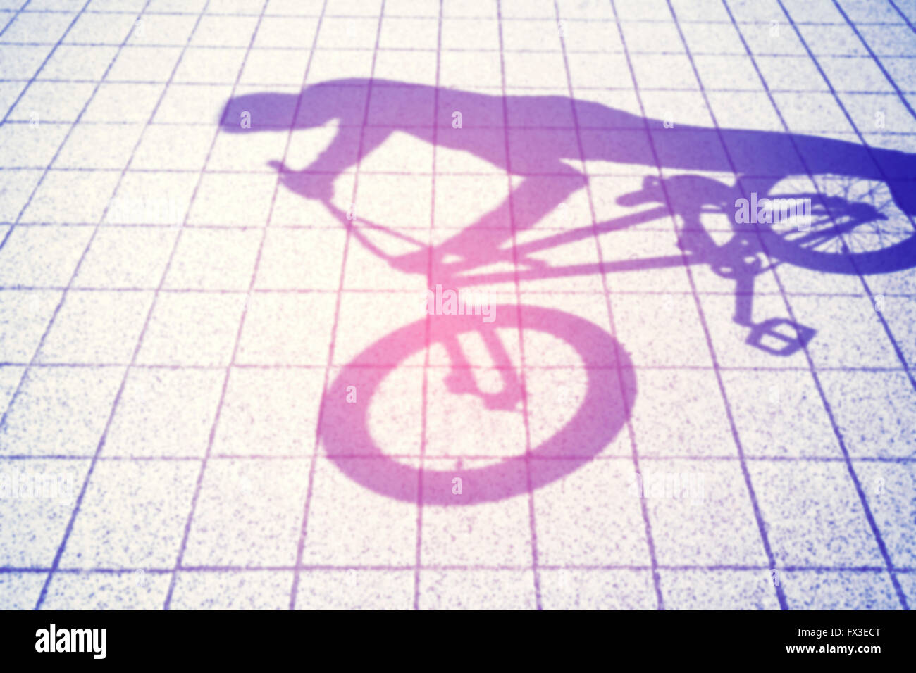 Retro toned blurred shadow of a teenager riding a bmx bike. Stock Photo