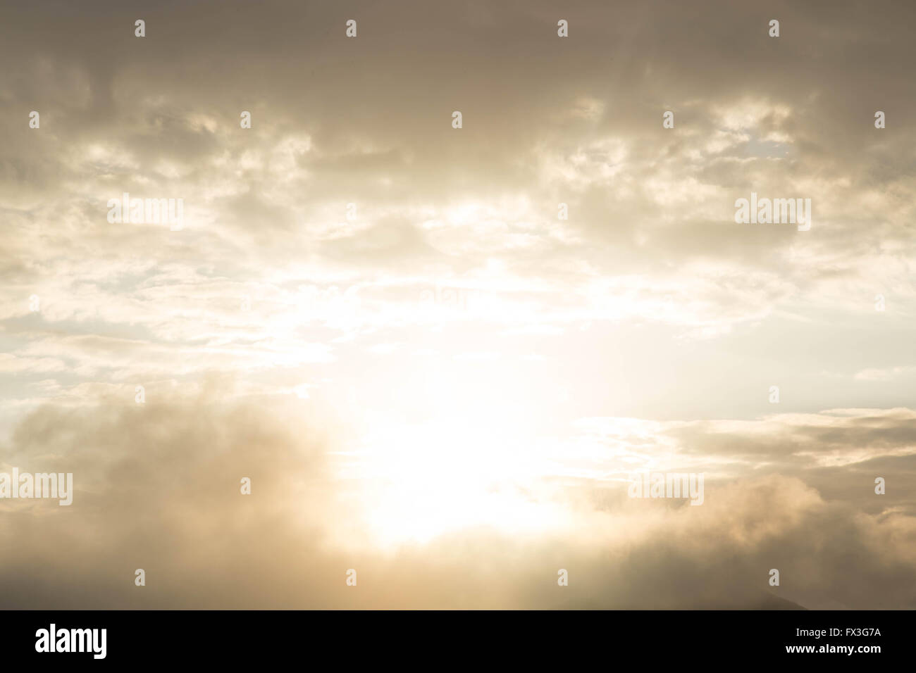 Beautiful sky with sun peaking through clouds. sky parting for golden sun Stock Photo