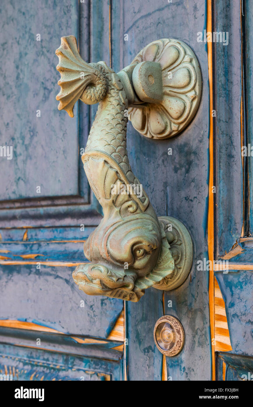 Doorknocker in the shape of a fish on an old door Stock Photo