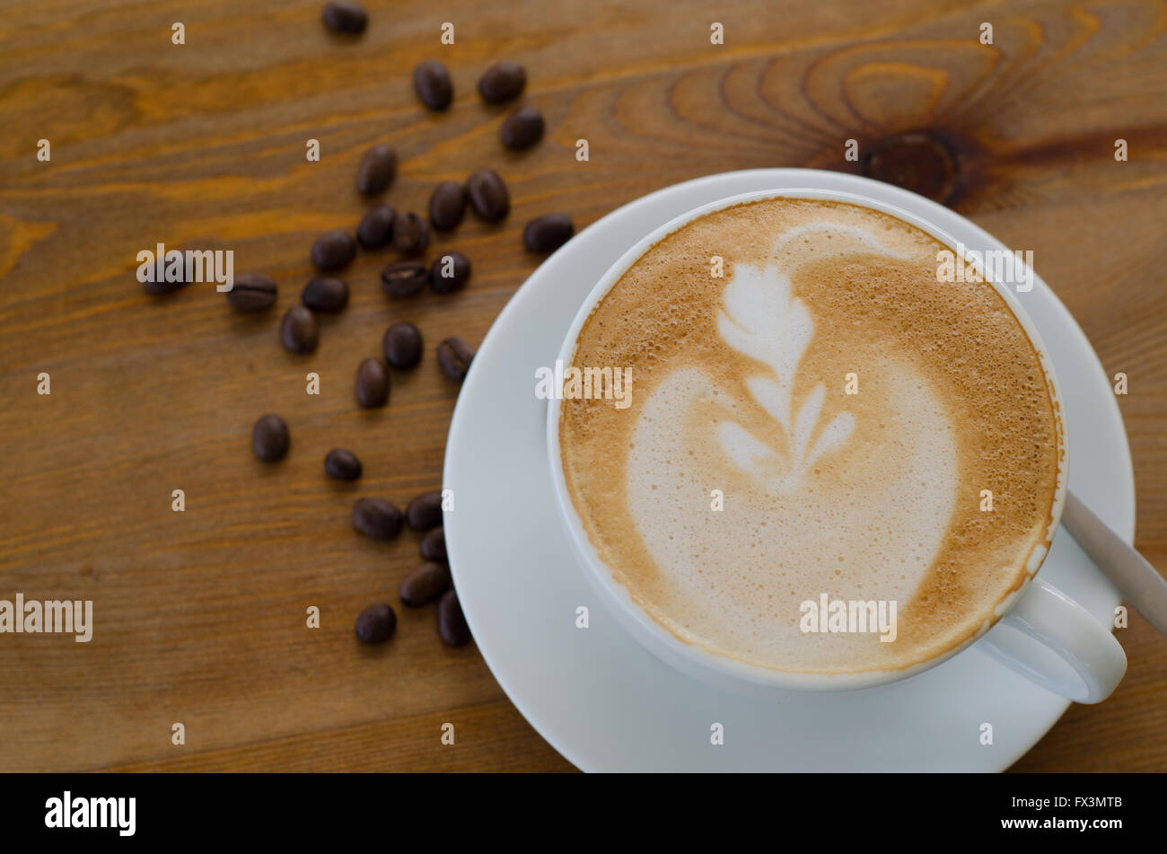 A Cup Of Cappuccino With Coffee Beans And Bread Stock Photo