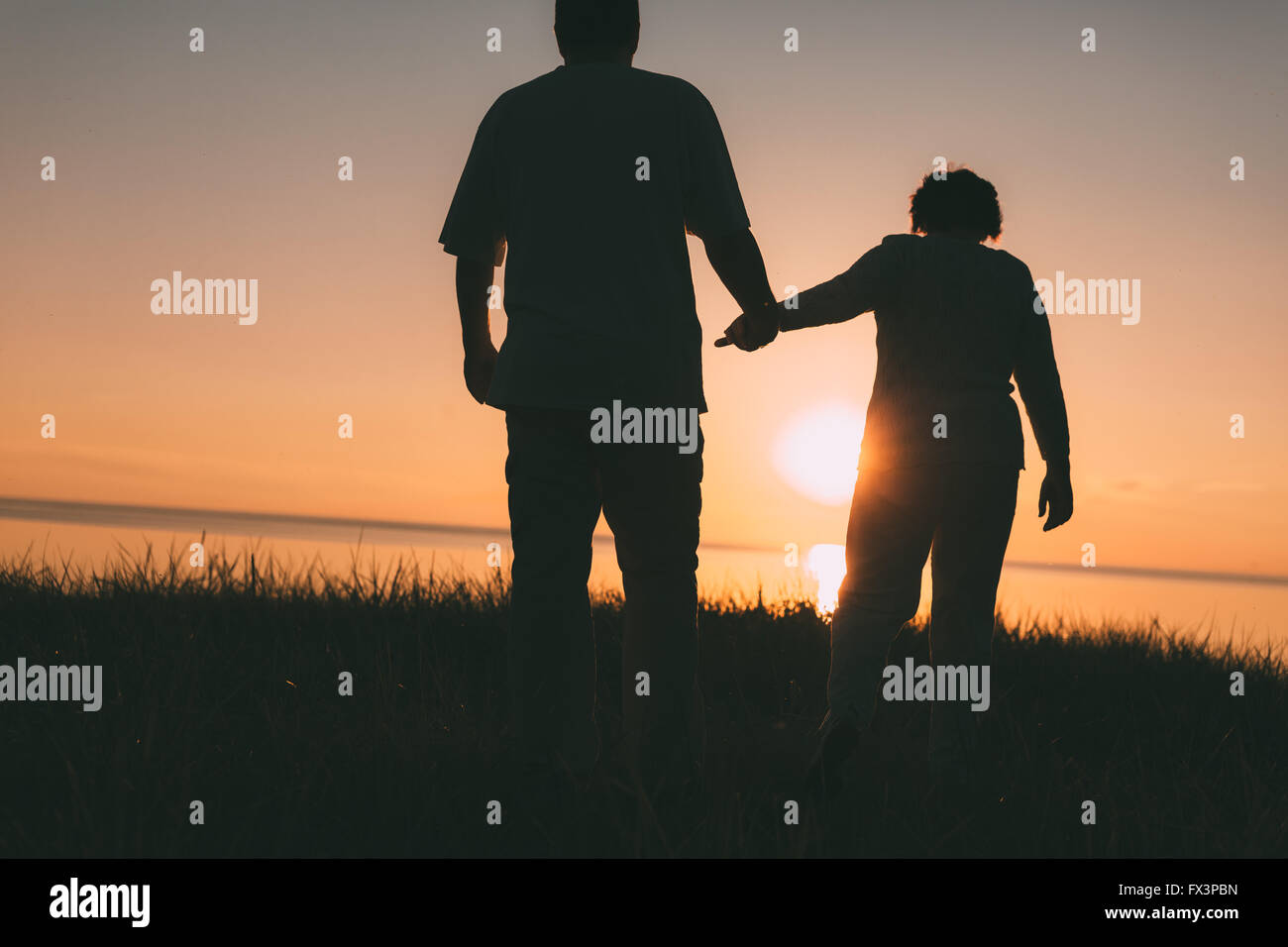 Adult couple silhouettes at sunset. Stock Photo