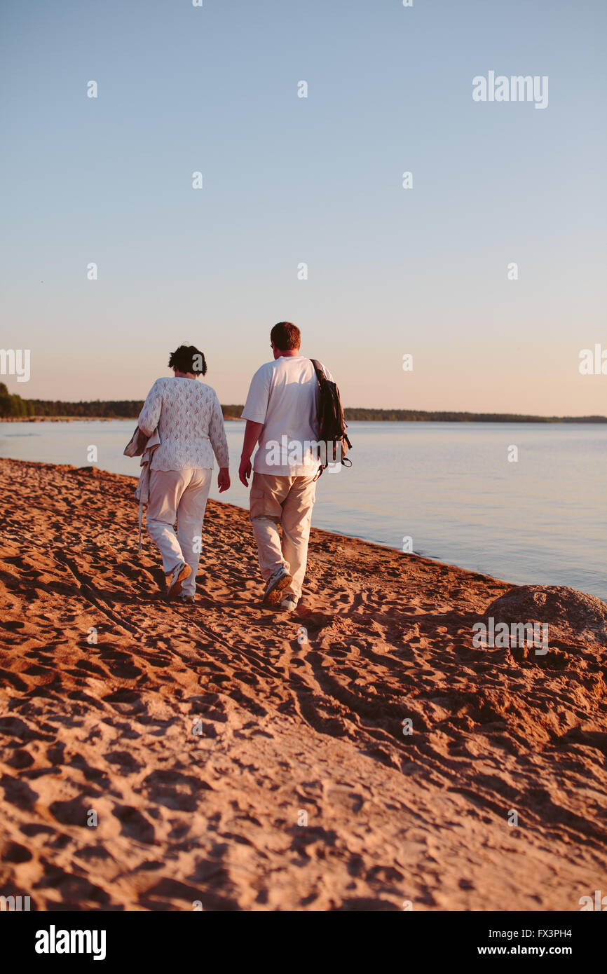Adult couple walking on the beach. Stock Photo