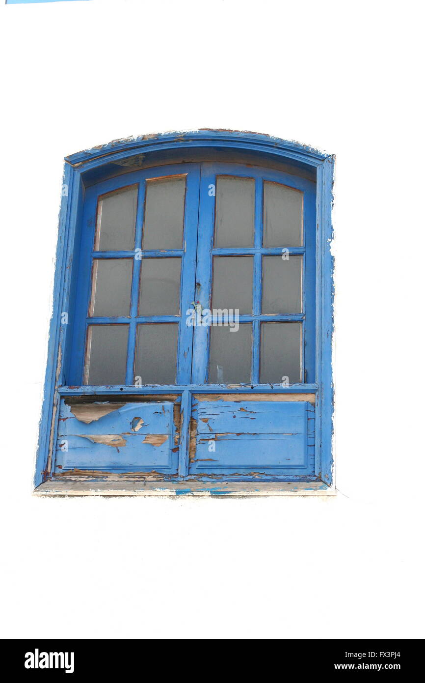 Blue multi-pane chipped wooden window second floor on a spanish street, Lanzarote Spain, old concept, peeling paint, multi panel window Stock Photo