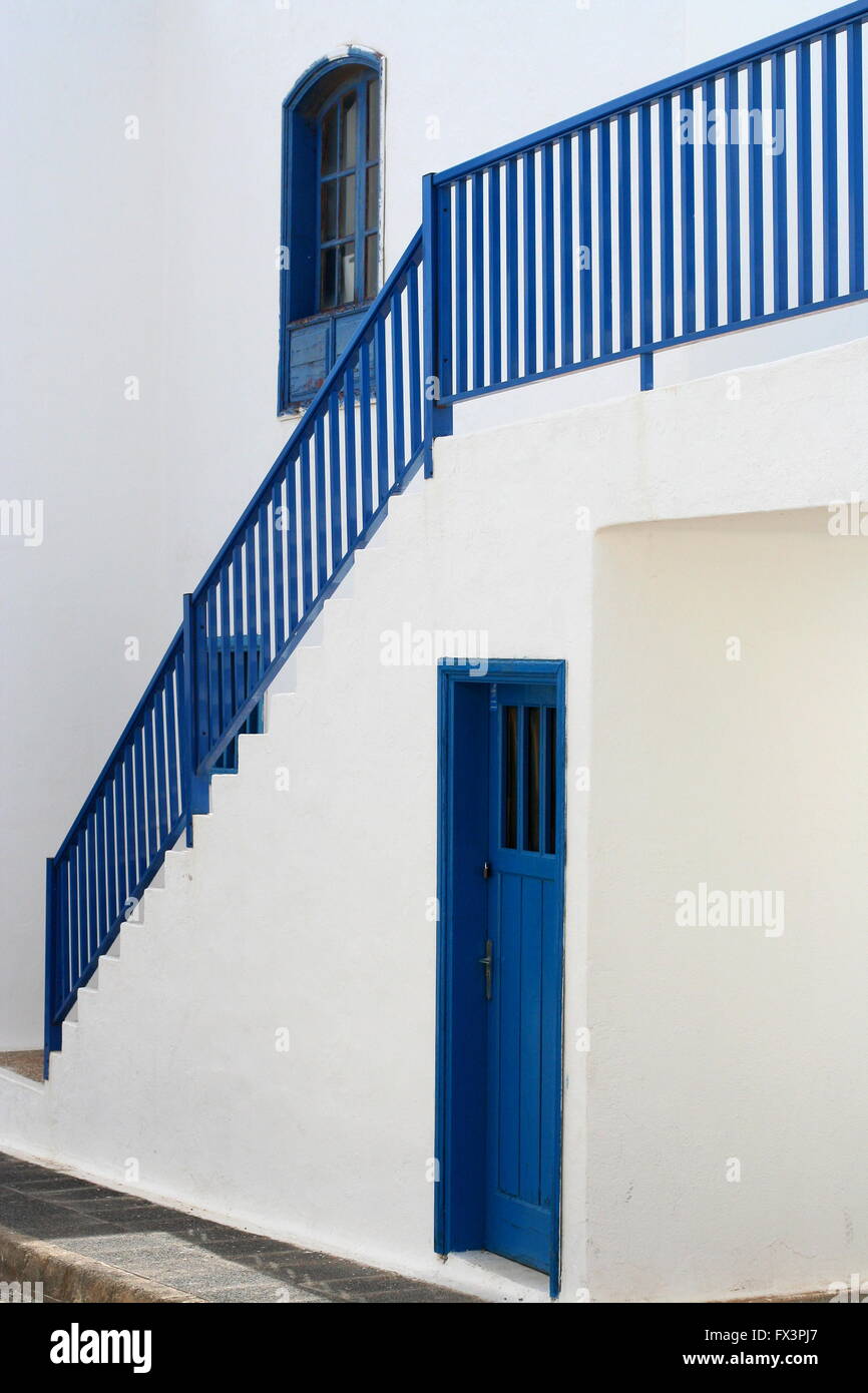 Side view Blue stairs and railings blue window and blue door, bright white wall  spanish street Lanzarote, spanish concept, simple architecture spain Stock Photo