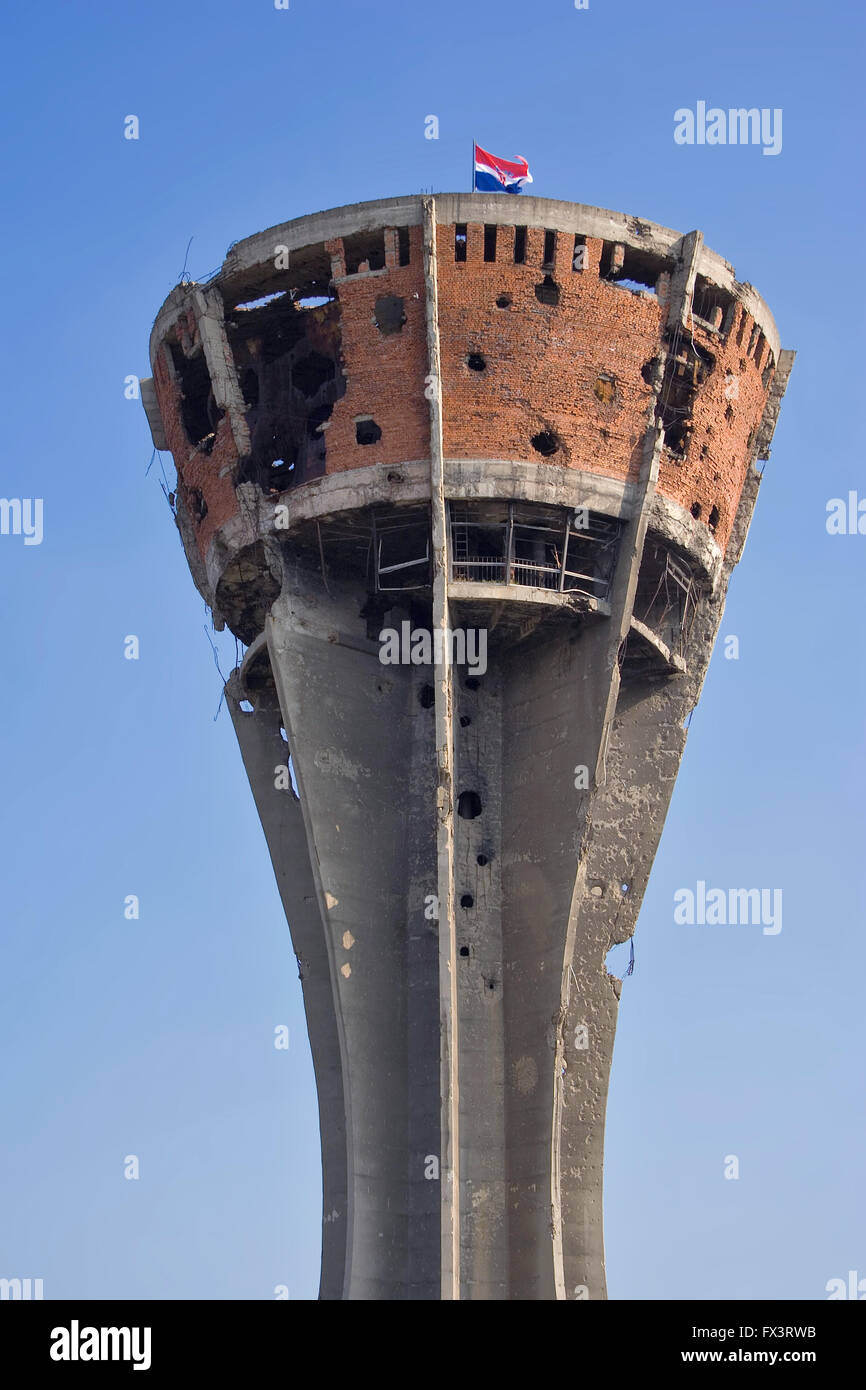historical water tower in Vukovar, Croatia, with visible war damage, left intentionally this way as a monument, Croatian flag Stock Photo