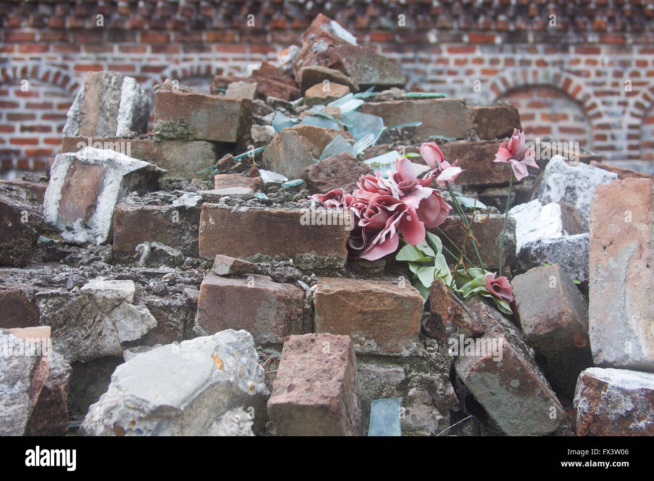 Destroyed, crumbled tomb, with faded flower, from a cemetery in New Orleans, Louisiana. Stock Photo