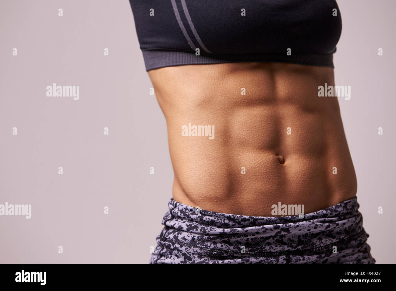 Mid-section crop shot of muscular young woman’s abs Stock Photo