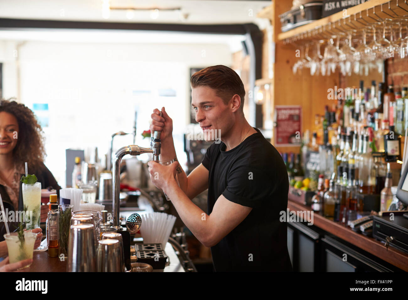 Bartender Serving Customers In Busy Bar Stock Photo Alamy