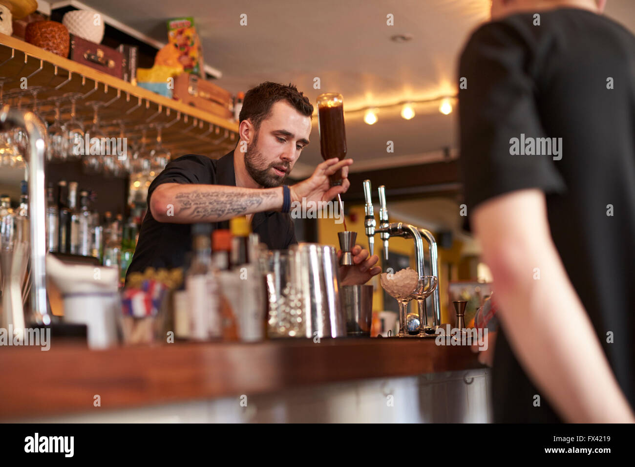 Bartender Giving Cocktail Making Lesson to Friends In Bar Stock