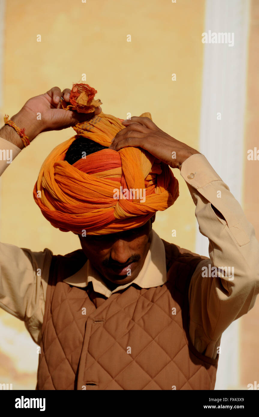 A man demonstrates how to put on a turban. He did this for tourist visitors to Jodhpur's Meherangarth Fort. Stock Photo
