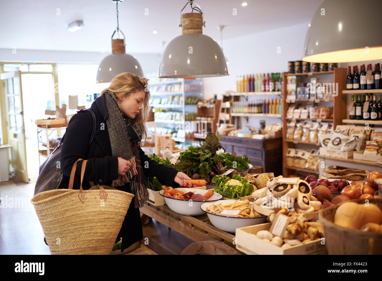 Woman Shopping For Organic Produce In Delicatessen Stock Photo