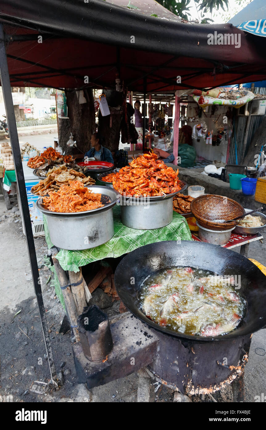 Frying fish by cooking in boiling oil at a local street stall by U Bein