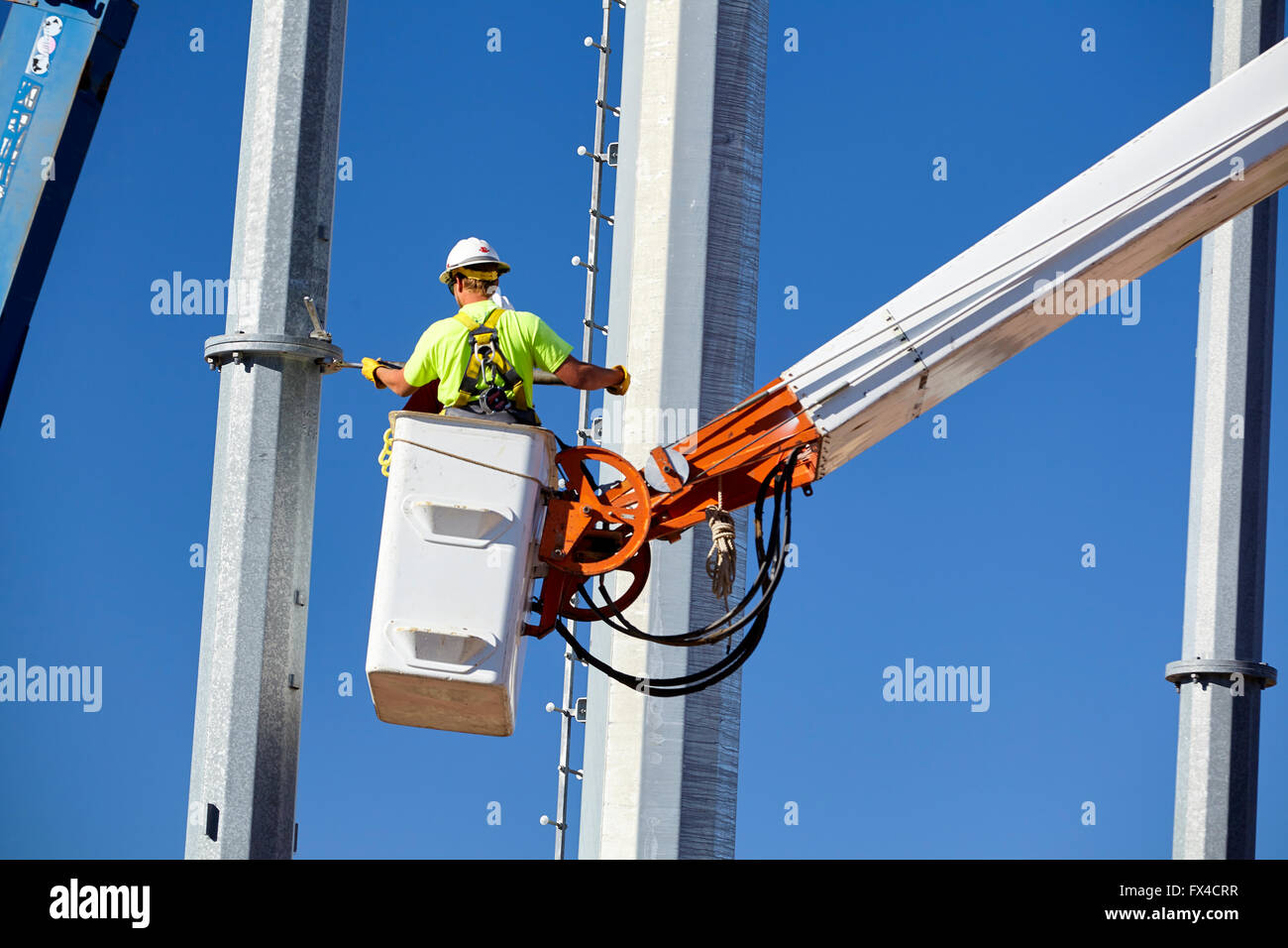 high voltage power line transmission tower workers with crane high boom