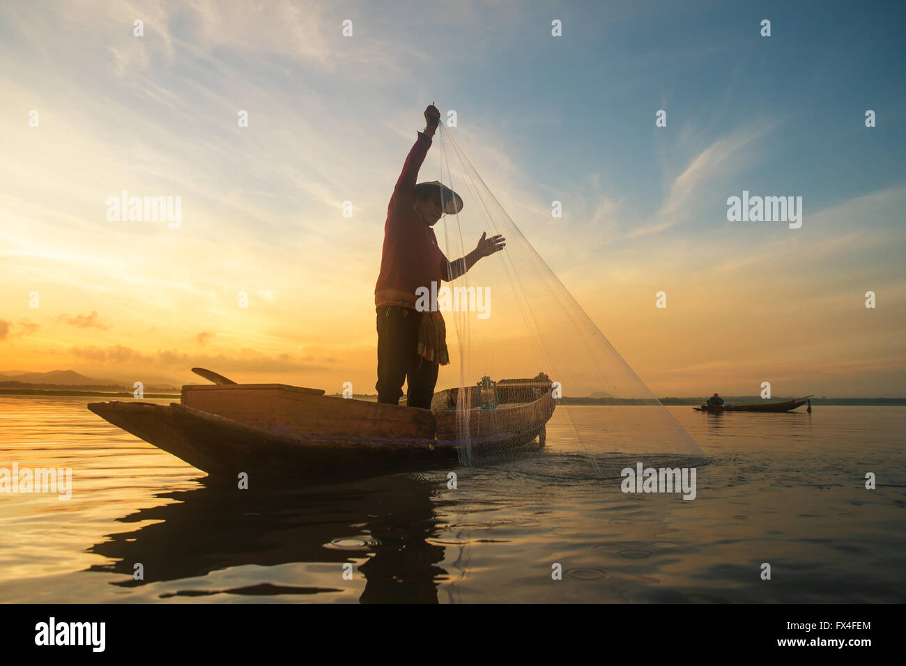 Fisherman fishing at lake in Morning, Thailand. Stock Photo
