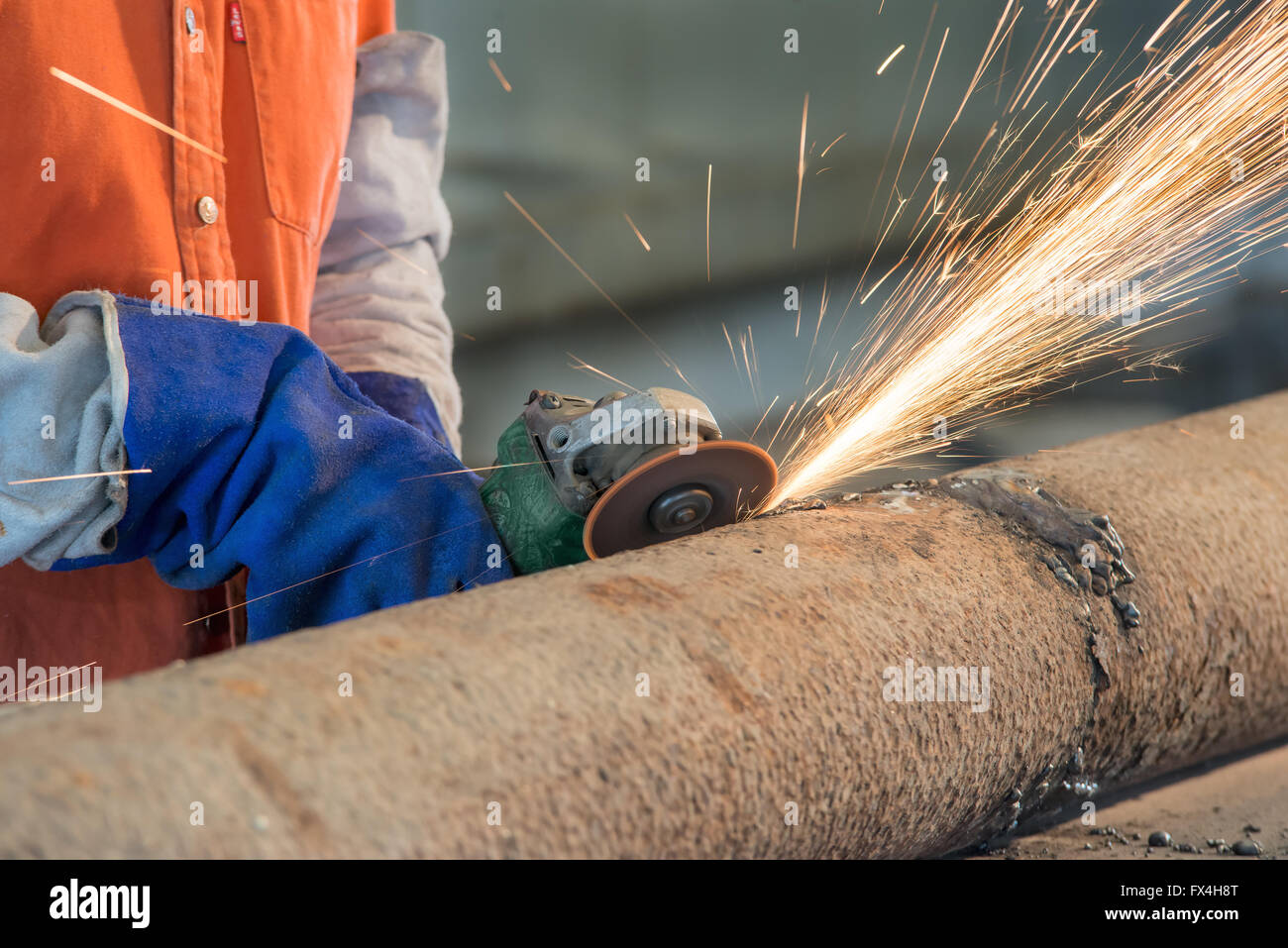 Industrial worker cutting and welding metal with many sharp sparks Stock Photo