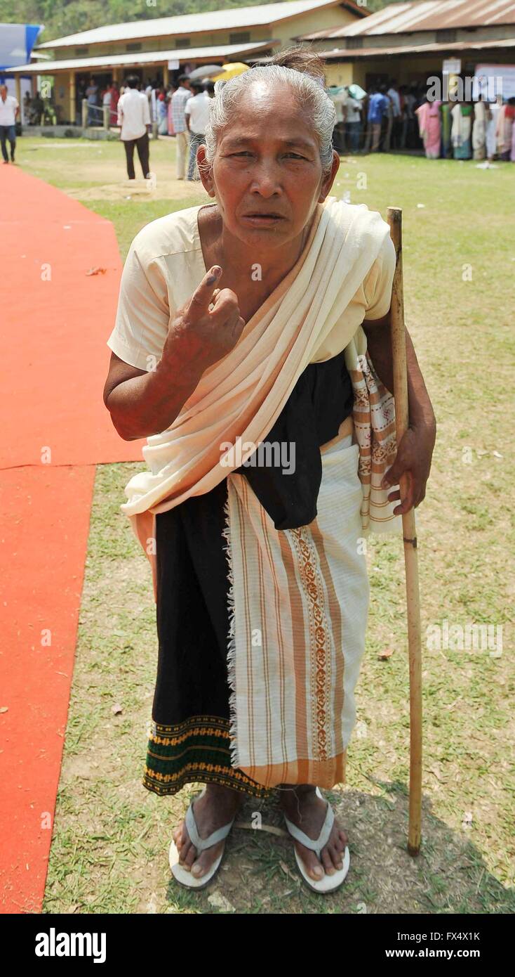 An elderly woman belonging to the Rava tribe, holds up her inked stained finger showing that she cast her vote in the Assam Assembly elections April 11, 2016 in Chakardoin, Assam, India. Long lines at polling stations and high turn out resulted in sporadic clashes and police firing that resulted in the death of an elderly voter. Stock Photo