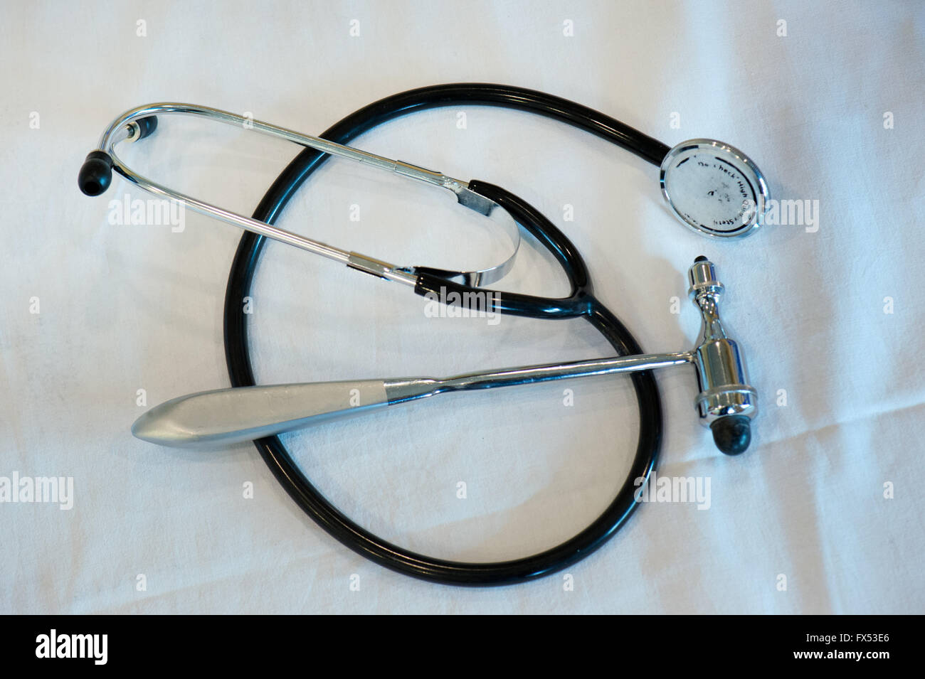 ILLUSTRATION A stethoscope and a reflex hammer lie on a white cloth
