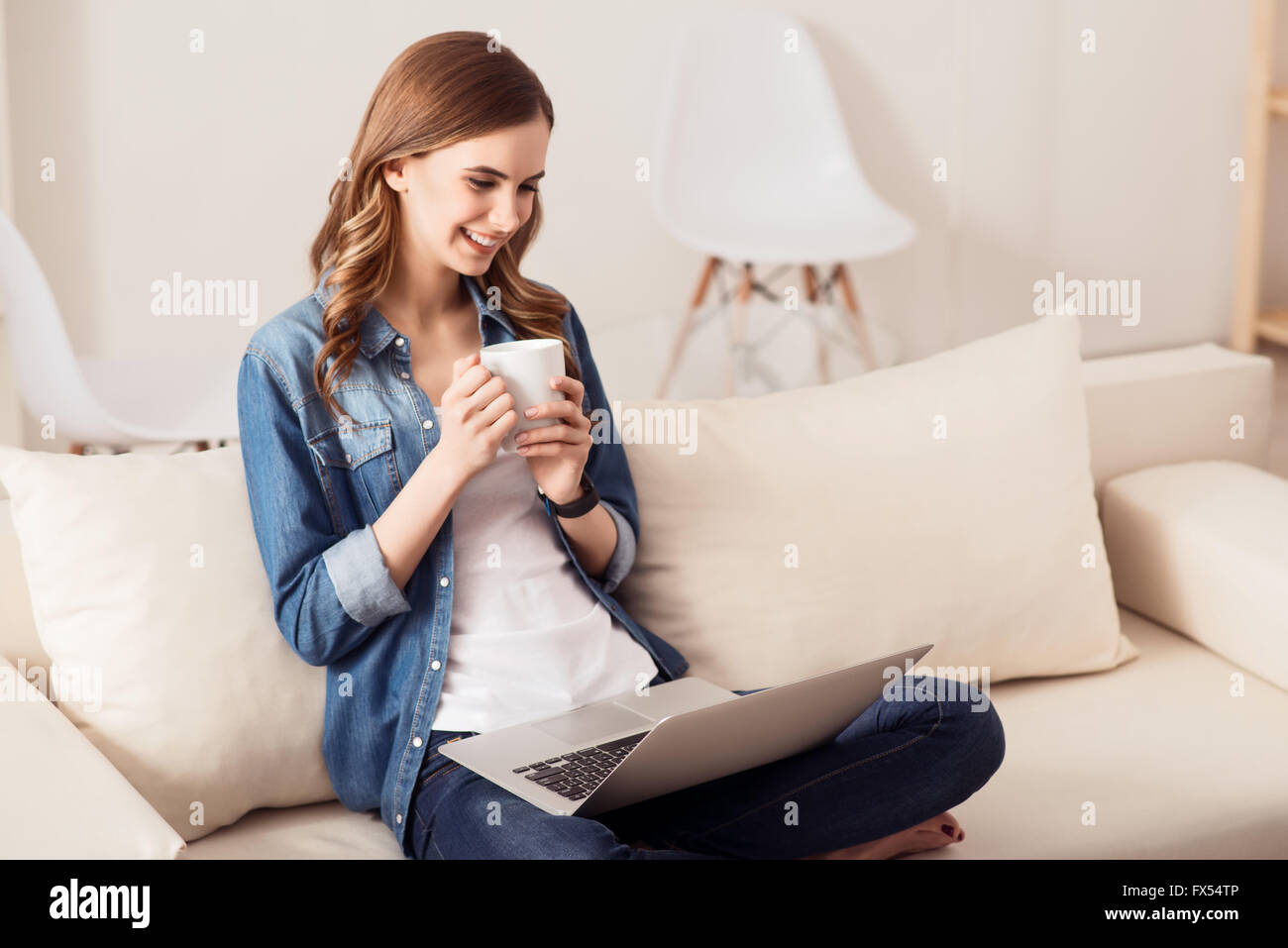 Cheerful girl sitting on the sofa Stock Photo - Alamy