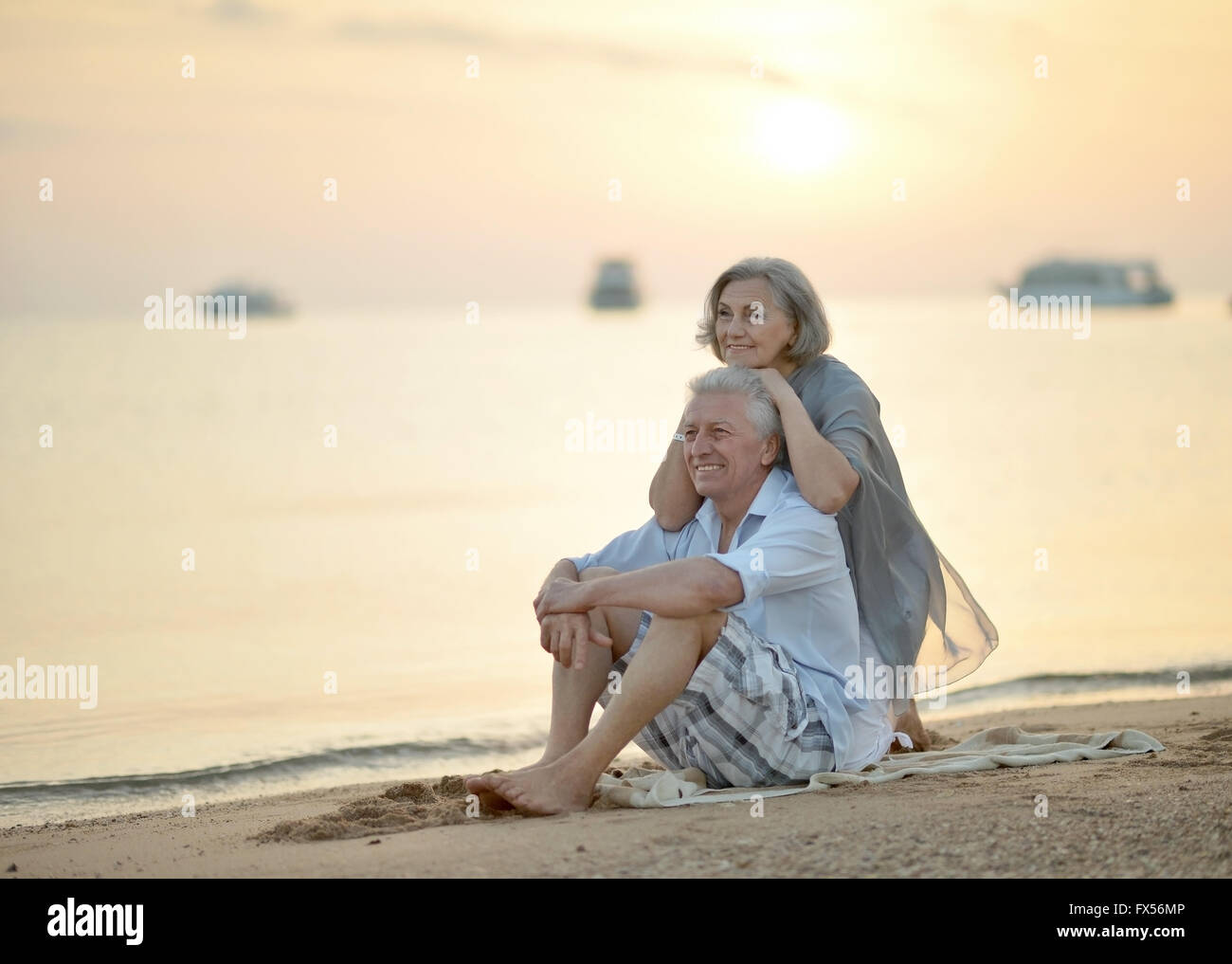 Mature couple relaxing on beach Stock Photo - Alamy