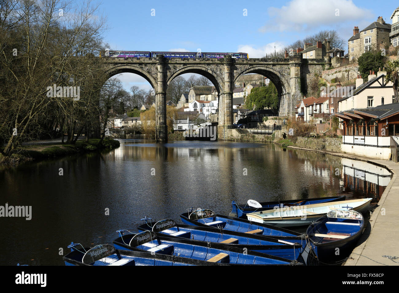 Sunshine hits a train as it crosses the River Nidd on the elegant viaduct in Knaresborough, North Yorkshire. The viaduct  was co Stock Photo