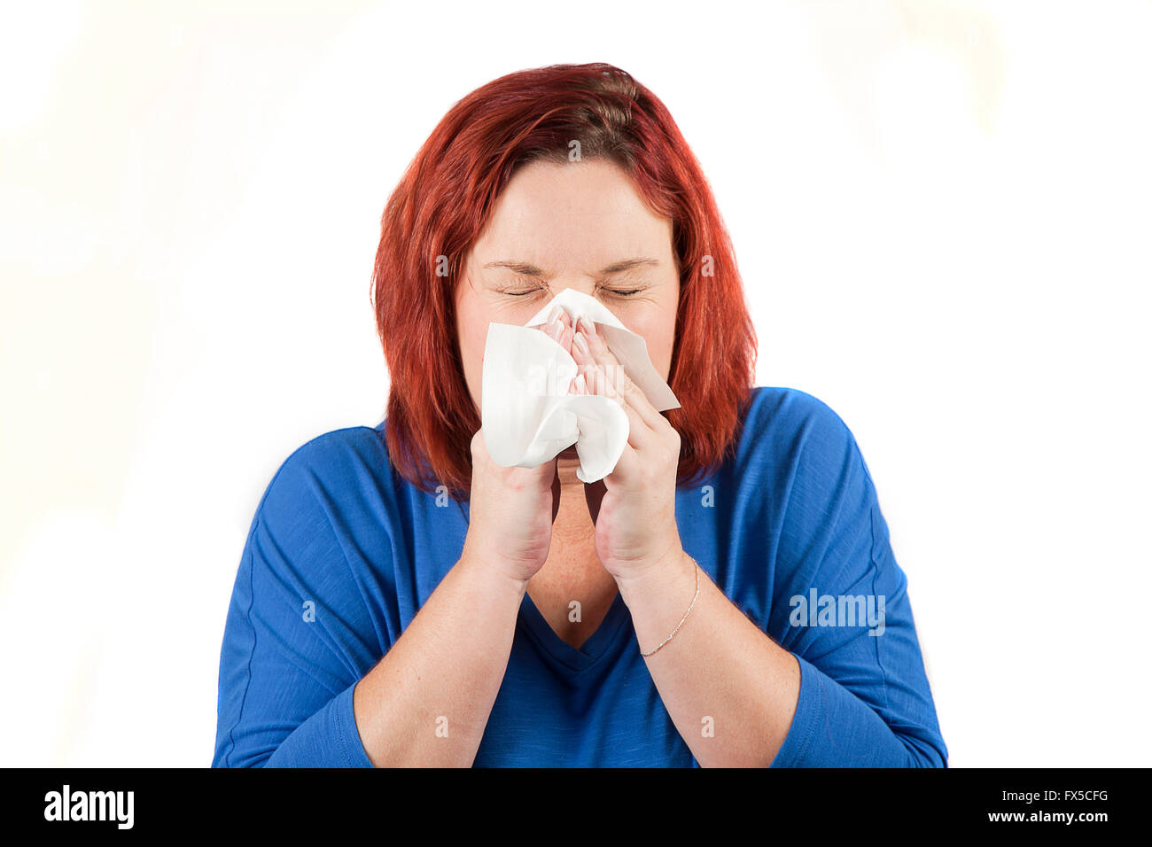 Woman with red hair blowing nose or sneezing Stock Photo