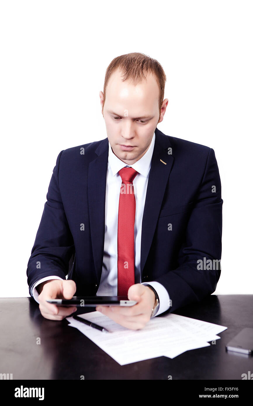 Serious American Businessman in red tie at the table working on Stock Photo