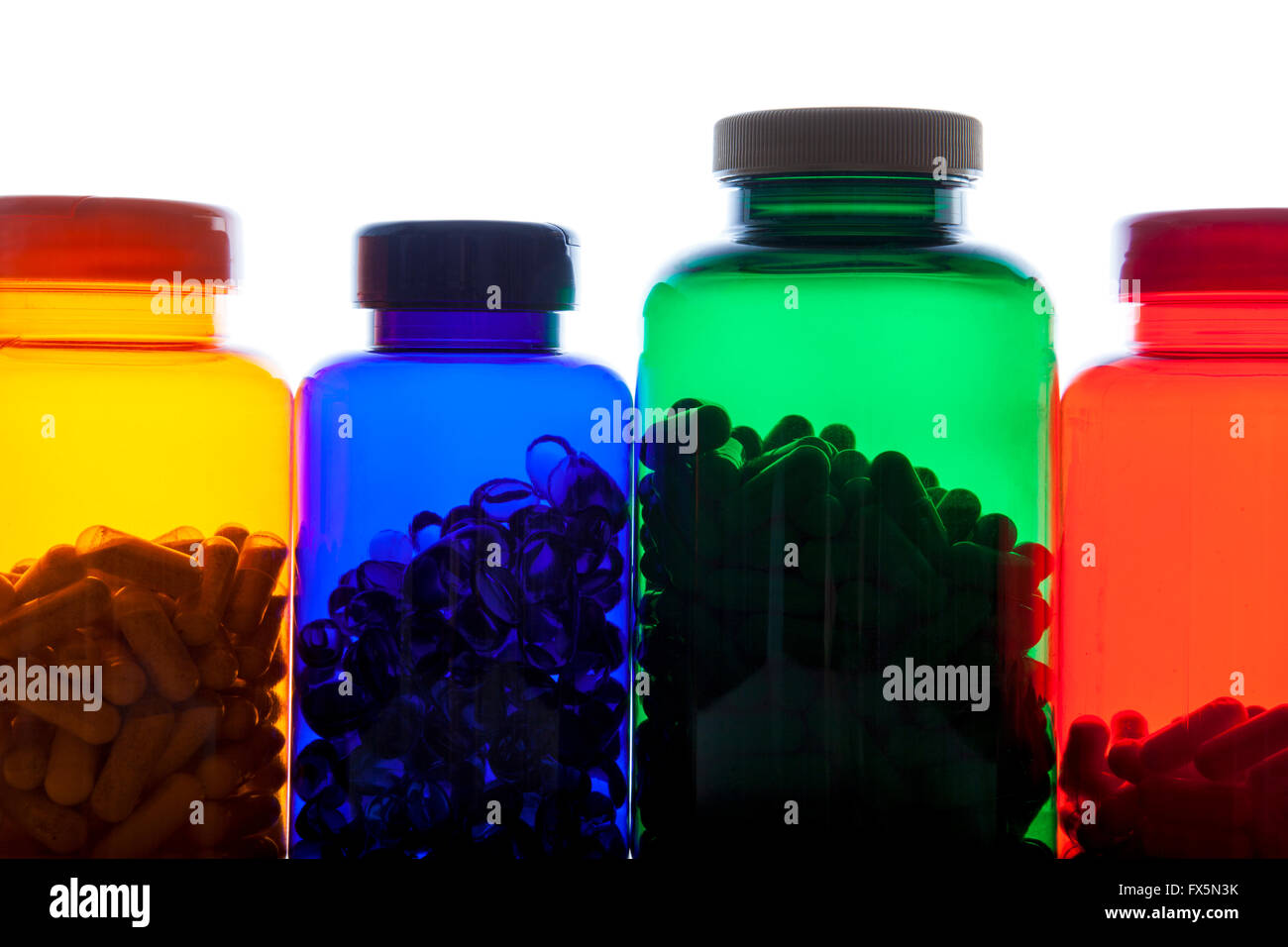 Colourful pill bottles full of pills against white background Stock Photo