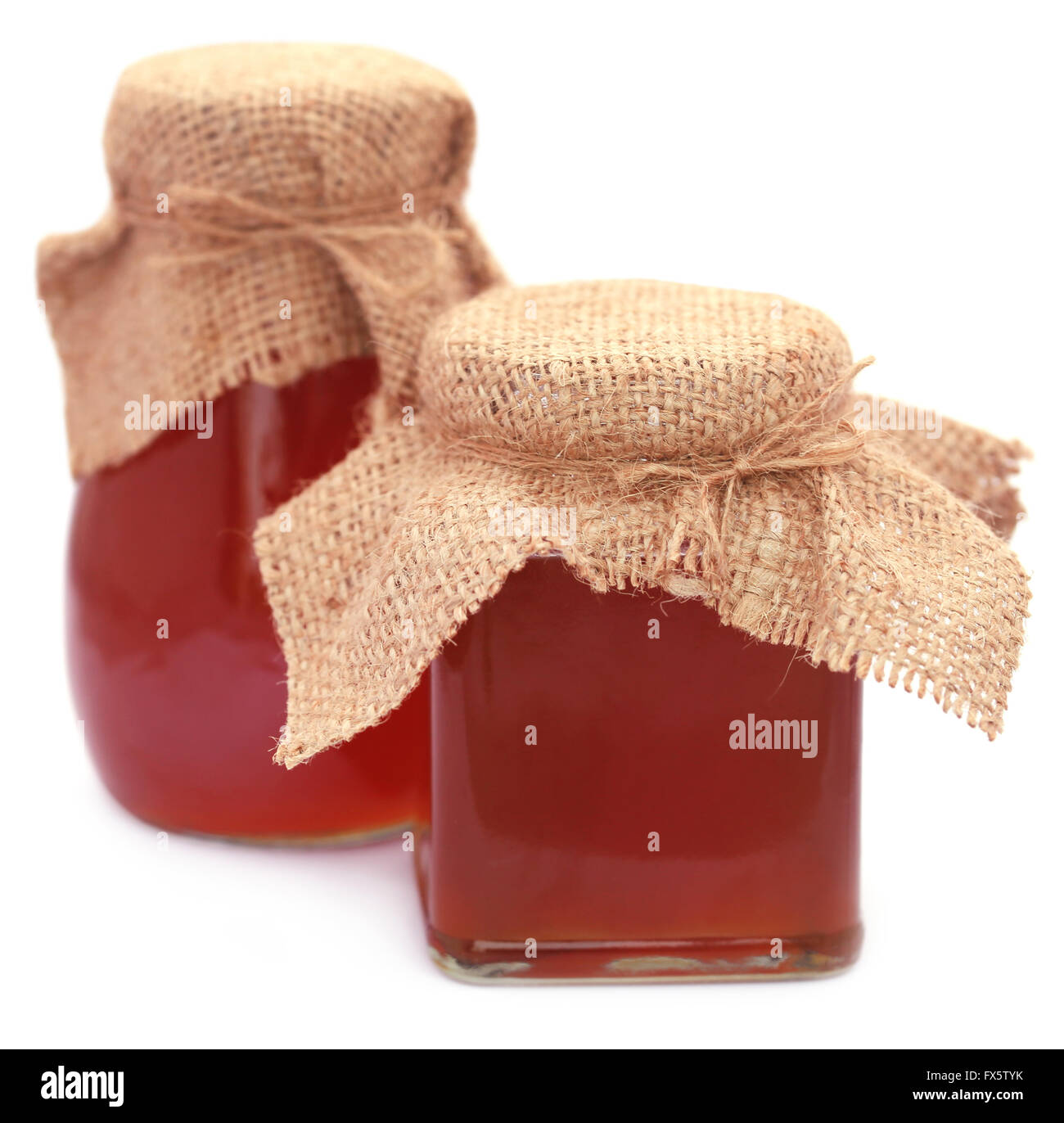 Honey in glass jar over white background Stock Photo Alamy
